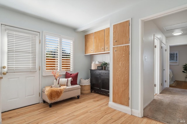 sitting room with light wood-style flooring and attic access