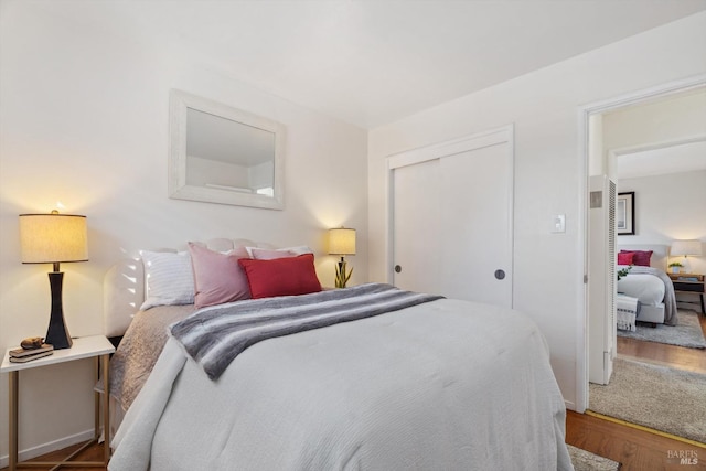 bedroom featuring a closet, wood finished floors, and baseboards