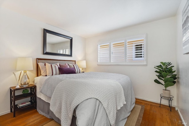 bedroom with wood finished floors and baseboards