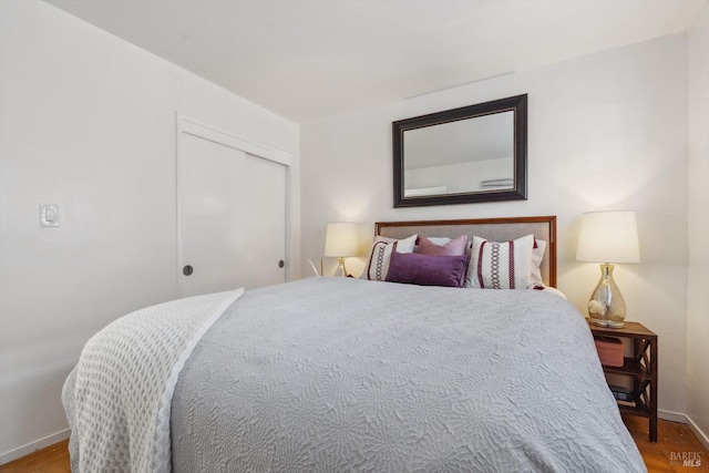 bedroom with baseboards, a closet, and wood finished floors