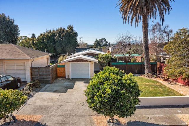 view of front facade featuring driveway, a front lawn, and fence