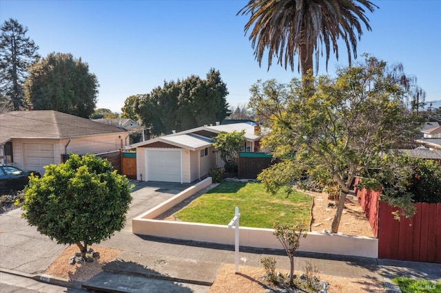 view of front facade with a fenced front yard, a front lawn, driveway, and a garage