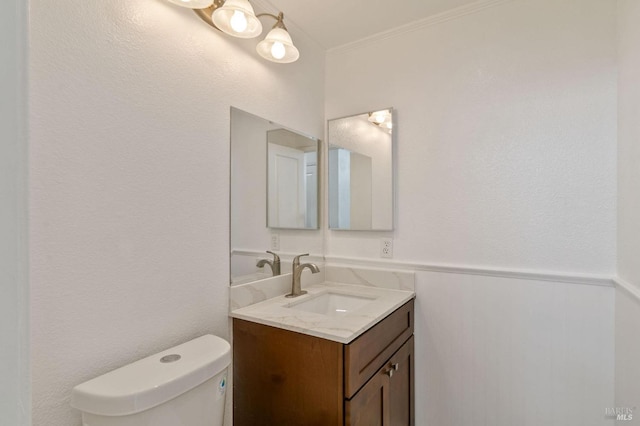 bathroom with vanity, ornamental molding, and toilet