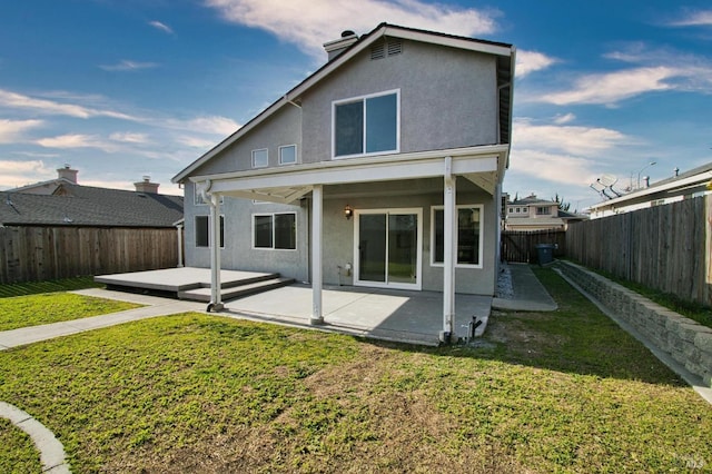 rear view of property featuring a lawn and a patio area