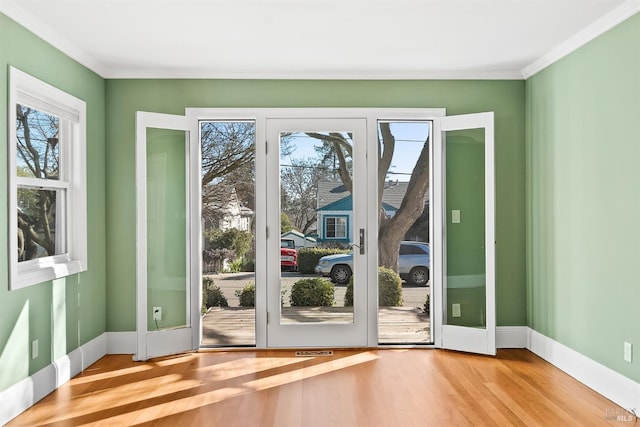 doorway to outside with hardwood / wood-style floors and crown molding