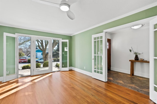 empty room featuring hardwood / wood-style floors, ornamental molding, french doors, and ceiling fan