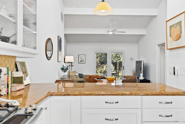 kitchen featuring white cabinetry, light stone counters, pendant lighting, and ceiling fan