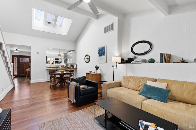 living room with vaulted ceiling with beams, dark wood-type flooring, and ceiling fan