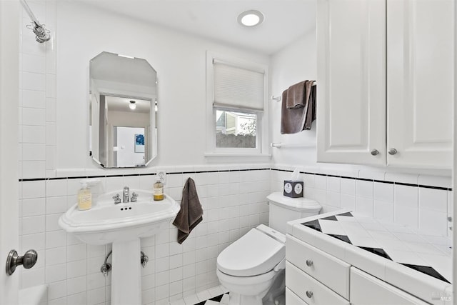 bathroom with tile walls and toilet