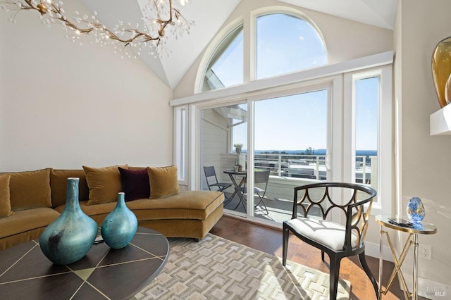 living room featuring high vaulted ceiling, a chandelier, and wood finished floors