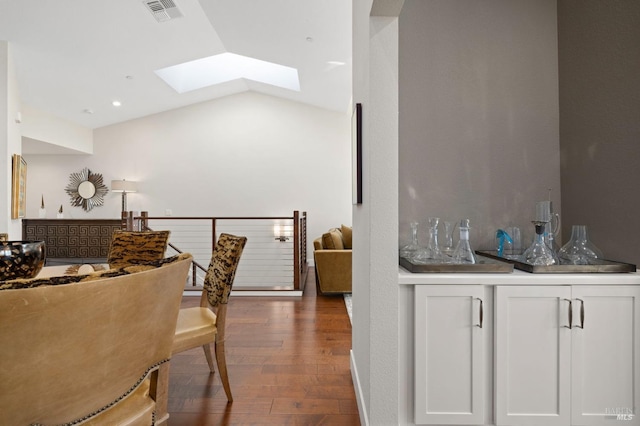 dining area with lofted ceiling with skylight, dark wood-style floors, and visible vents