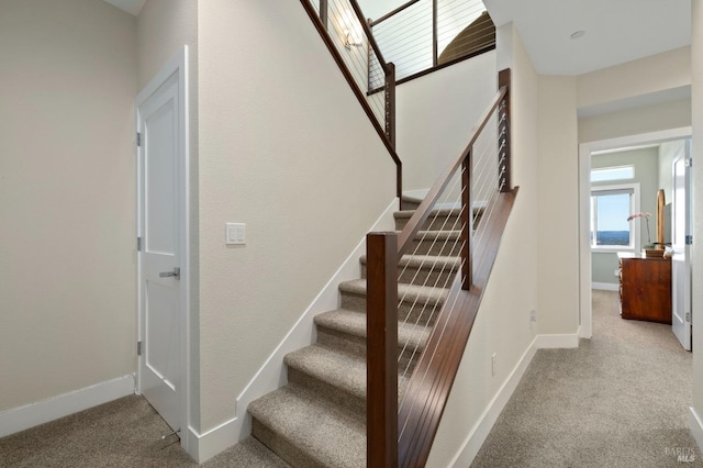 stairs featuring baseboards and carpet flooring