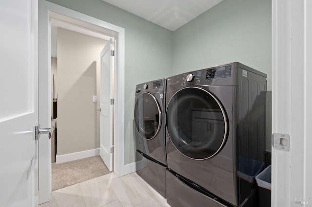 laundry room featuring light carpet, laundry area, baseboards, and washer and clothes dryer