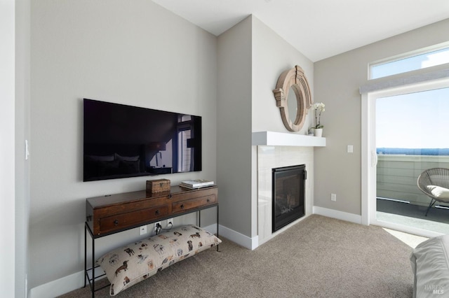 carpeted living room with baseboards and a tile fireplace