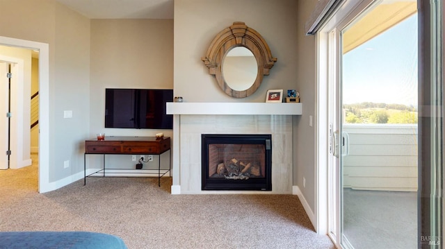carpeted living area with plenty of natural light, a tile fireplace, and baseboards