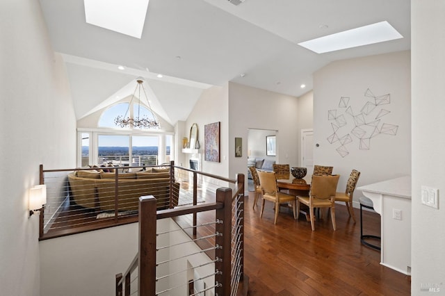 dining area featuring a skylight, recessed lighting, dark wood finished floors, a notable chandelier, and high vaulted ceiling