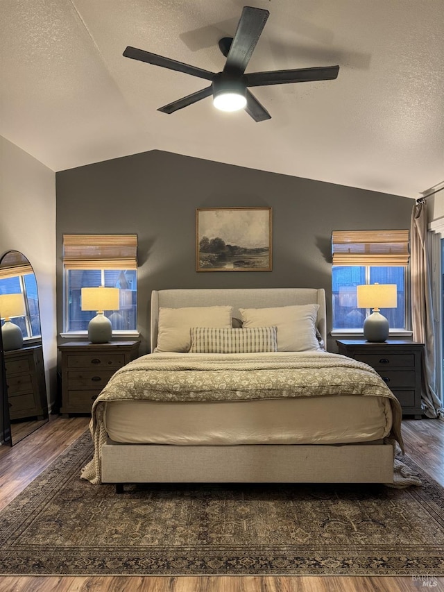 bedroom with lofted ceiling, dark wood-type flooring, and a textured ceiling