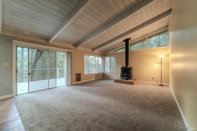 unfurnished living room featuring heating unit, a wood stove, vaulted ceiling with beams, carpet, and wood ceiling