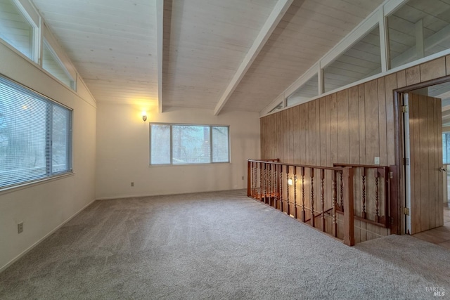 empty room featuring wood ceiling, lofted ceiling with beams, and carpet