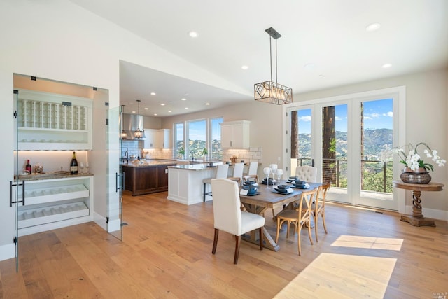 dining room with vaulted ceiling and light hardwood / wood-style flooring
