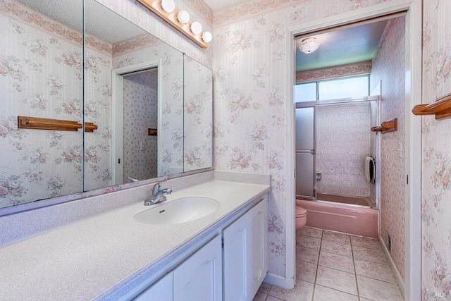 full bathroom featuring tile patterned flooring, vanity, shower / bath combination with glass door, and toilet