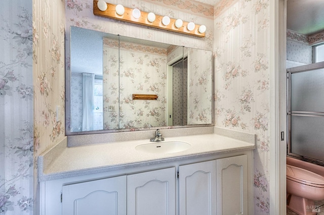 full bathroom featuring vanity, shower / bath combination with glass door, and toilet