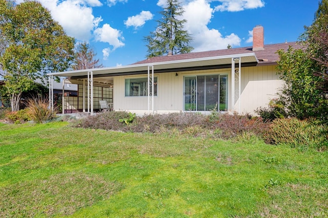 rear view of property featuring a yard