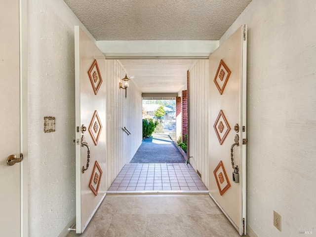 doorway to outside featuring a textured ceiling