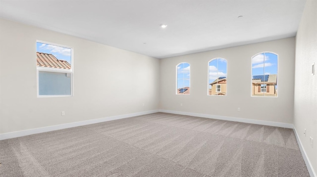 carpeted empty room featuring baseboards