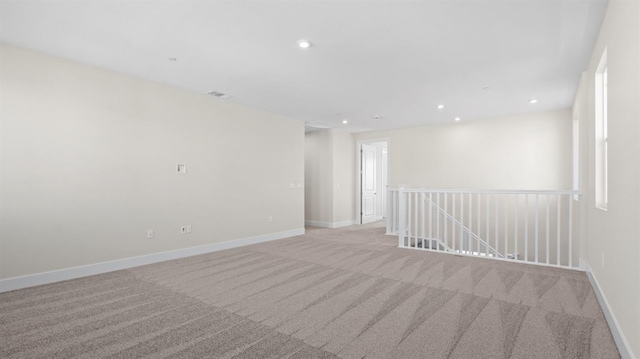 empty room with recessed lighting, light carpet, and baseboards