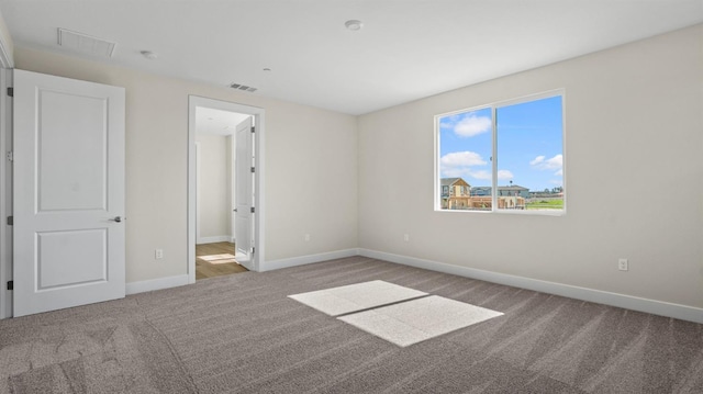 unfurnished bedroom with carpet floors, baseboards, and visible vents