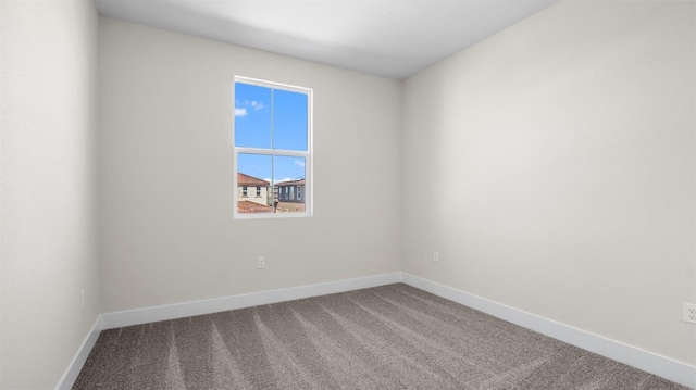 carpeted empty room featuring baseboards