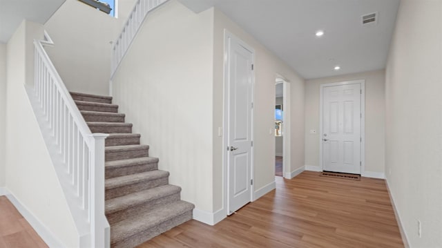 stairs with baseboards, visible vents, wood finished floors, and recessed lighting