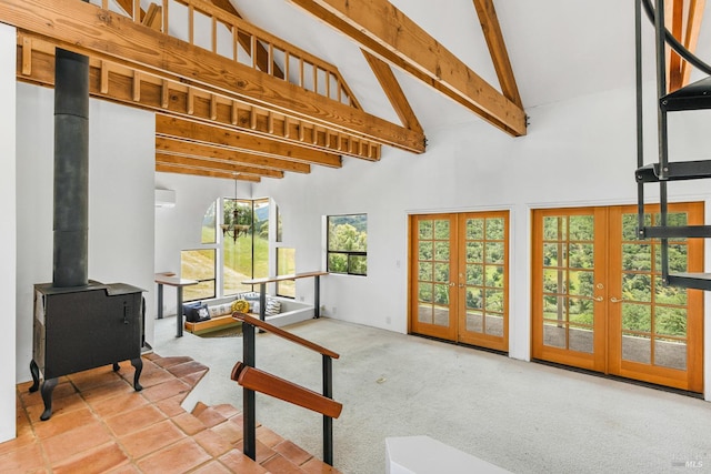 interior space featuring high vaulted ceiling, carpet floors, a wood stove, beam ceiling, and french doors