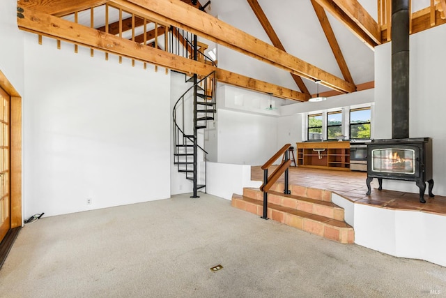 carpeted living room featuring beam ceiling, high vaulted ceiling, and a wood stove