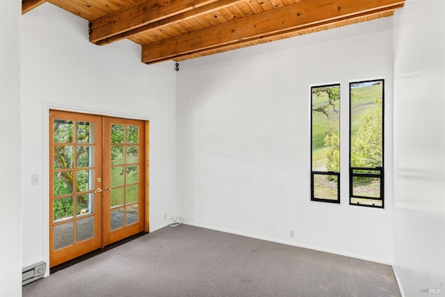 spare room featuring french doors, wooden ceiling, baseboard heating, beamed ceiling, and carpet