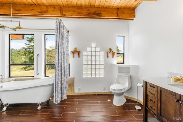 bathroom featuring toilet, plenty of natural light, beamed ceiling, and a bathing tub