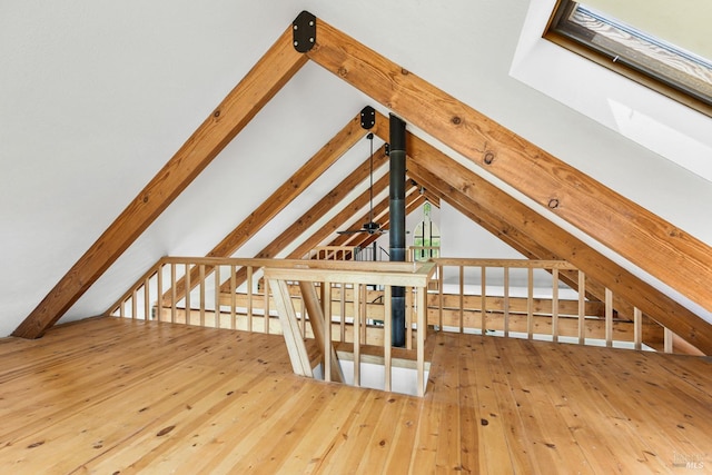 additional living space with hardwood / wood-style flooring and lofted ceiling with beams