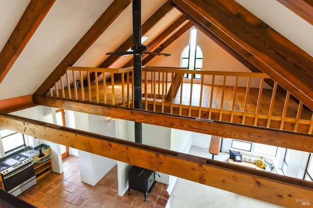 interior space with lofted ceiling with beams and ceiling fan