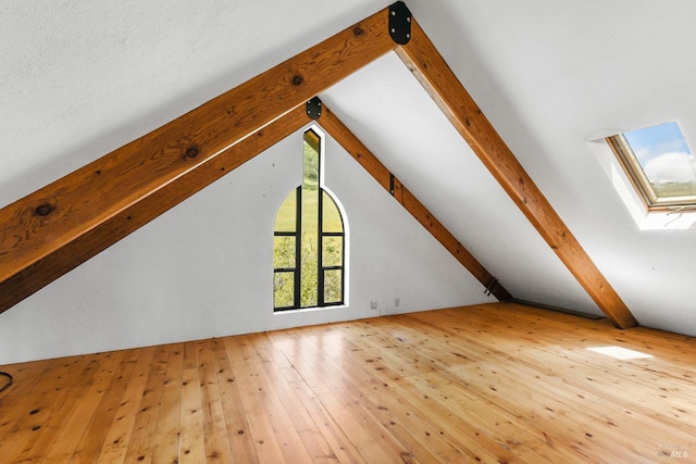 bonus room featuring hardwood / wood-style flooring and lofted ceiling with skylight