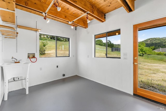 interior space featuring beam ceiling, wooden ceiling, and concrete floors