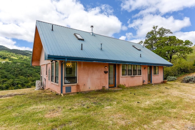 view of front of house featuring a front yard and central air condition unit