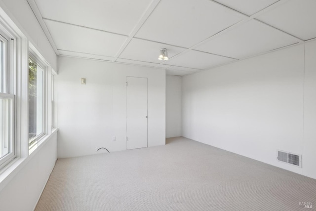 unfurnished room featuring a paneled ceiling and carpet