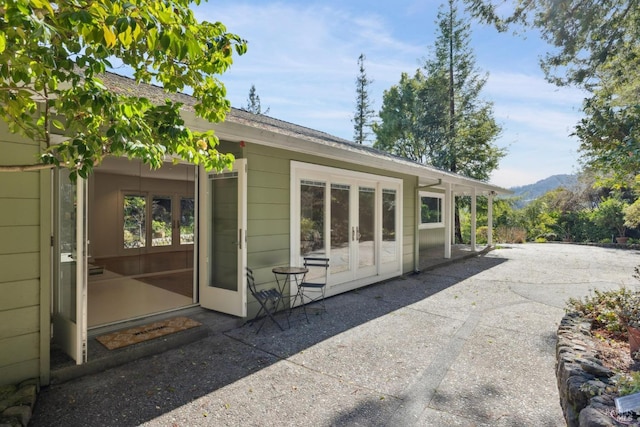 rear view of property with a mountain view and a patio area