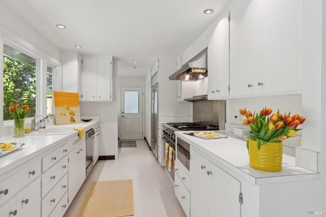 kitchen with sink, white cabinetry, backsplash, stainless steel appliances, and exhaust hood