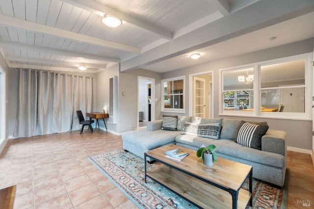 living area featuring light tile patterned floors, beamed ceiling, baseboards, and an inviting chandelier