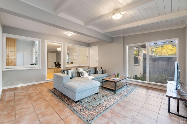 living room featuring light tile patterned floors, beamed ceiling, wood ceiling, and baseboards