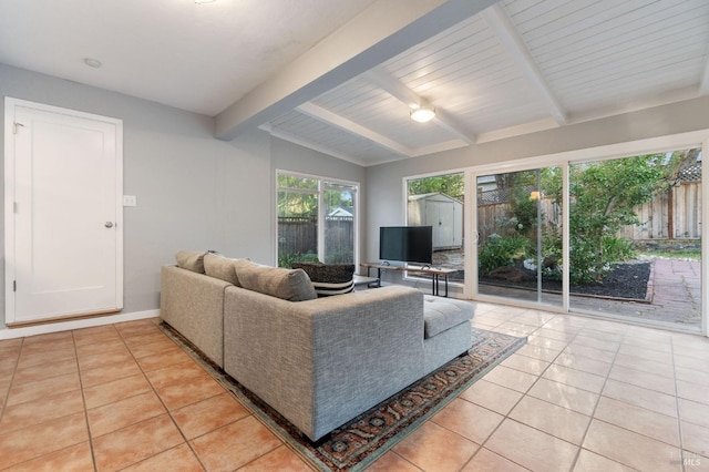 living room with light tile patterned floors, beam ceiling, and baseboards