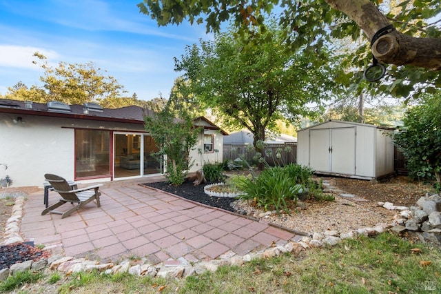 back of property featuring fence, a shed, stucco siding, an outbuilding, and a patio
