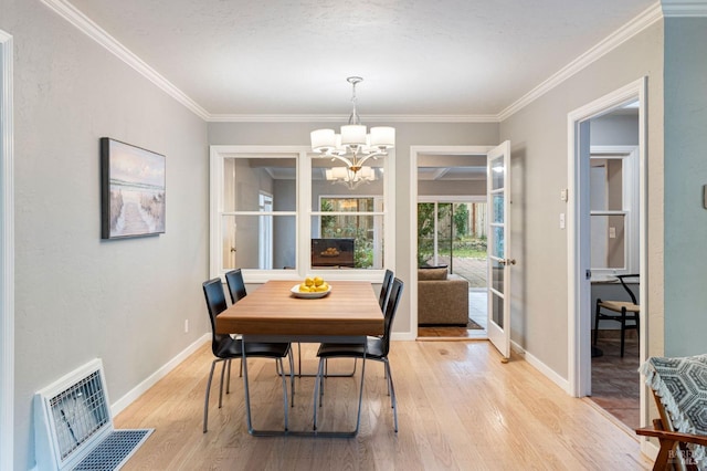 dining room featuring a chandelier, baseboards, and light wood-style floors
